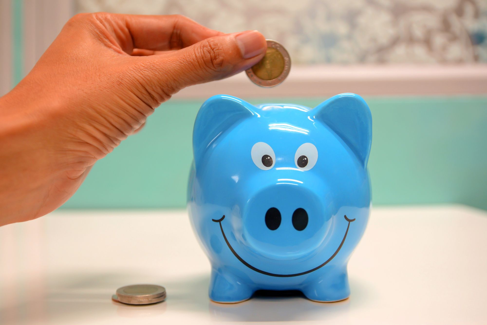 Hand dropping coin inside a piggy vest